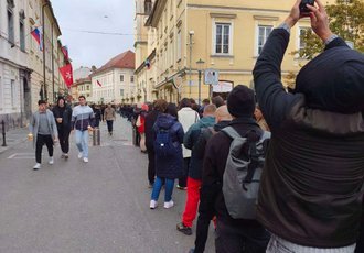 NEVERJETNI PRIZORI SREDI LJUBLJANE! DOLGE KOLONE, PETJE IN VEČURNO ČAKANJE – Poglejte, kaj se je dogajalo pred veleposlaništvom! (VIDEO)